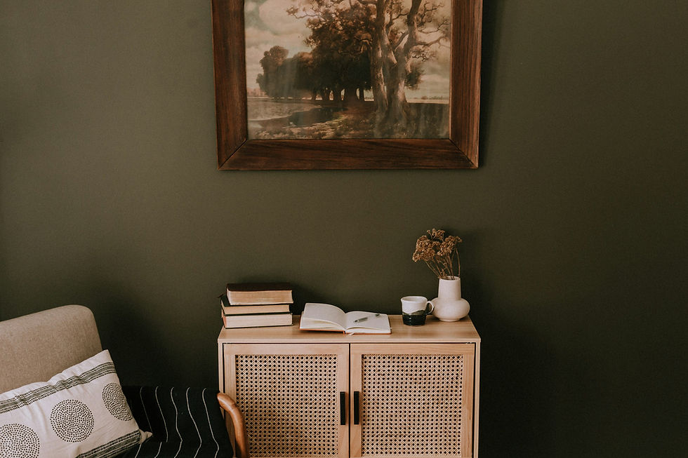 Minimalist home decor, green wall with a wicker cabinet and water color picture.