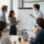 Team collaborating on documents at a whiteboard