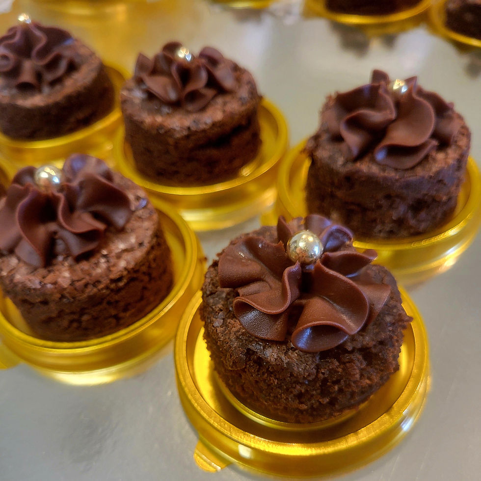 Mini brownie with chocolate topping and sugar pearl in elegant gold packaging