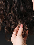 Close-up of a professional hairdresser using scissors to trim individual curls Specialized