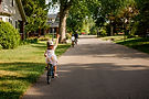 family riding bikes on residential street