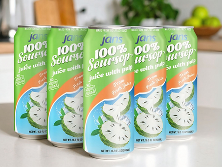 Cans of Jans 100% soursop juice with pulp, labeled "no added sugar" and "from fresh juice," on a kitchen counter with a fruit bowl.