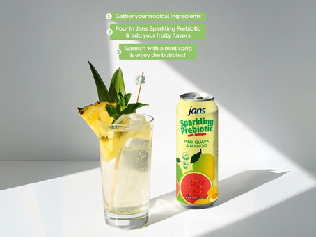 Tropical drink in a glass with pineapple, mint, and a skewer beside a "jans Sparkling Prebiotic" can on a bright, minimalist background.