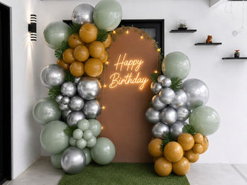 Green, silver and gold birthday balloon backdrop by ABI DECOR in Florida.