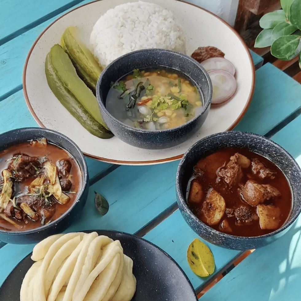 Delicious Indian cuisine with rice, pickles, and various curries on a table