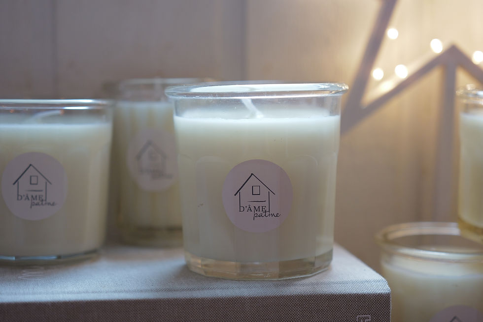 Gros plan sur une bougie artisanale D’âme Patine en pot de confiture ancien, cire végétale parfumée.