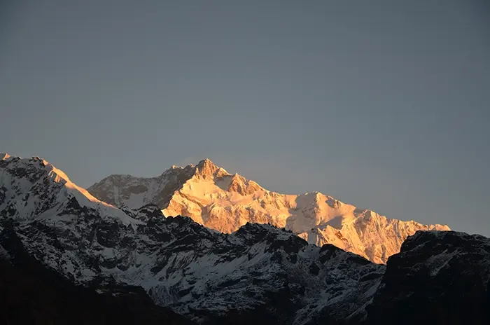 Golden sunrise view of Mount Kanchenjunga, the third-highest peak in the world, seen from Yuksom, Dzongri top West Sikkim, with snow-covered ridges glowing in early morning light.