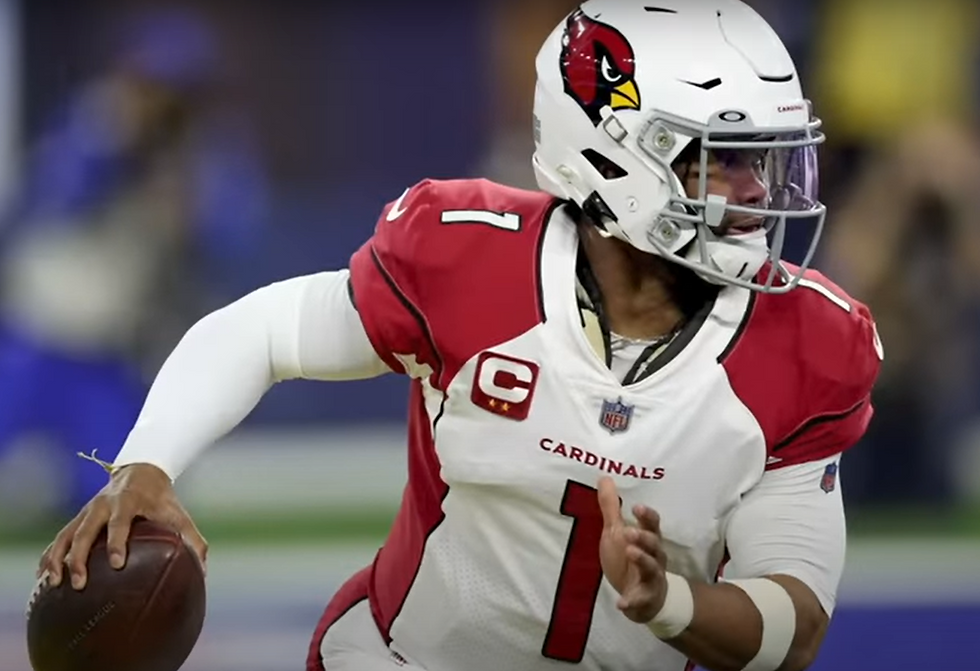 Kyler Murray scrambles and throws a pass.
