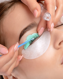 Make-up artist makes the procedure of lamination and dyeing of eyelashes to a beautiful wo