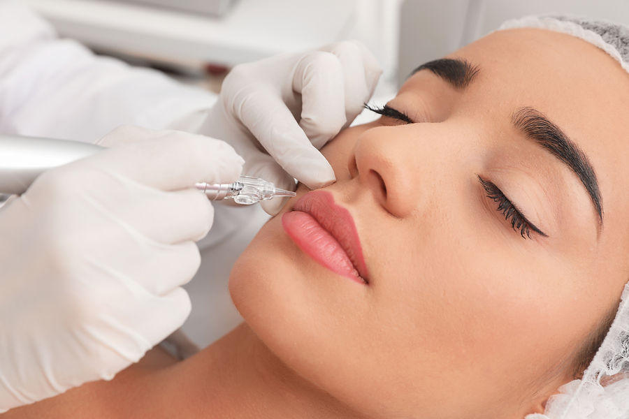 Young woman undergoing procedure of permanent lip makeup in tattoo salon, closeup.jpg