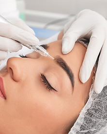 Young woman undergoing procedure of permanent eyebrow makeup in tattoo salon, closeup.jpg
