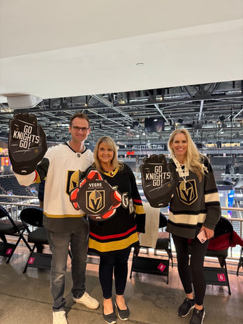  Group posing with Vegas Knights themed props at a hockey game