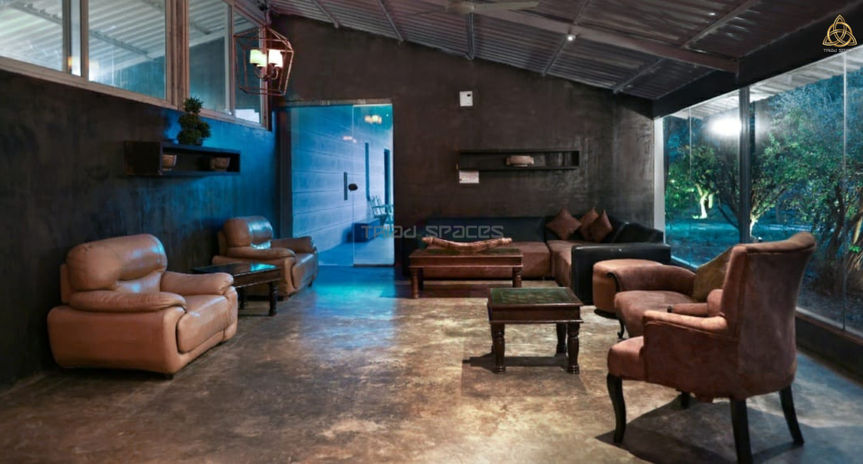 Floor-to-ceiling windows flood the room with natural light, offering panoramic views of the surrounding landscape and creating a bright and airy ambiance.