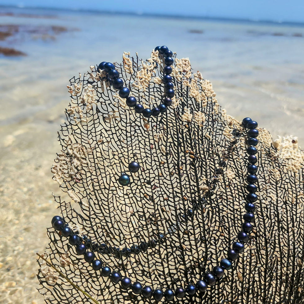 Tahitian black pearl necklace on coral, ocean background, The Siren's Embrace by Pirate Jewelry Co.