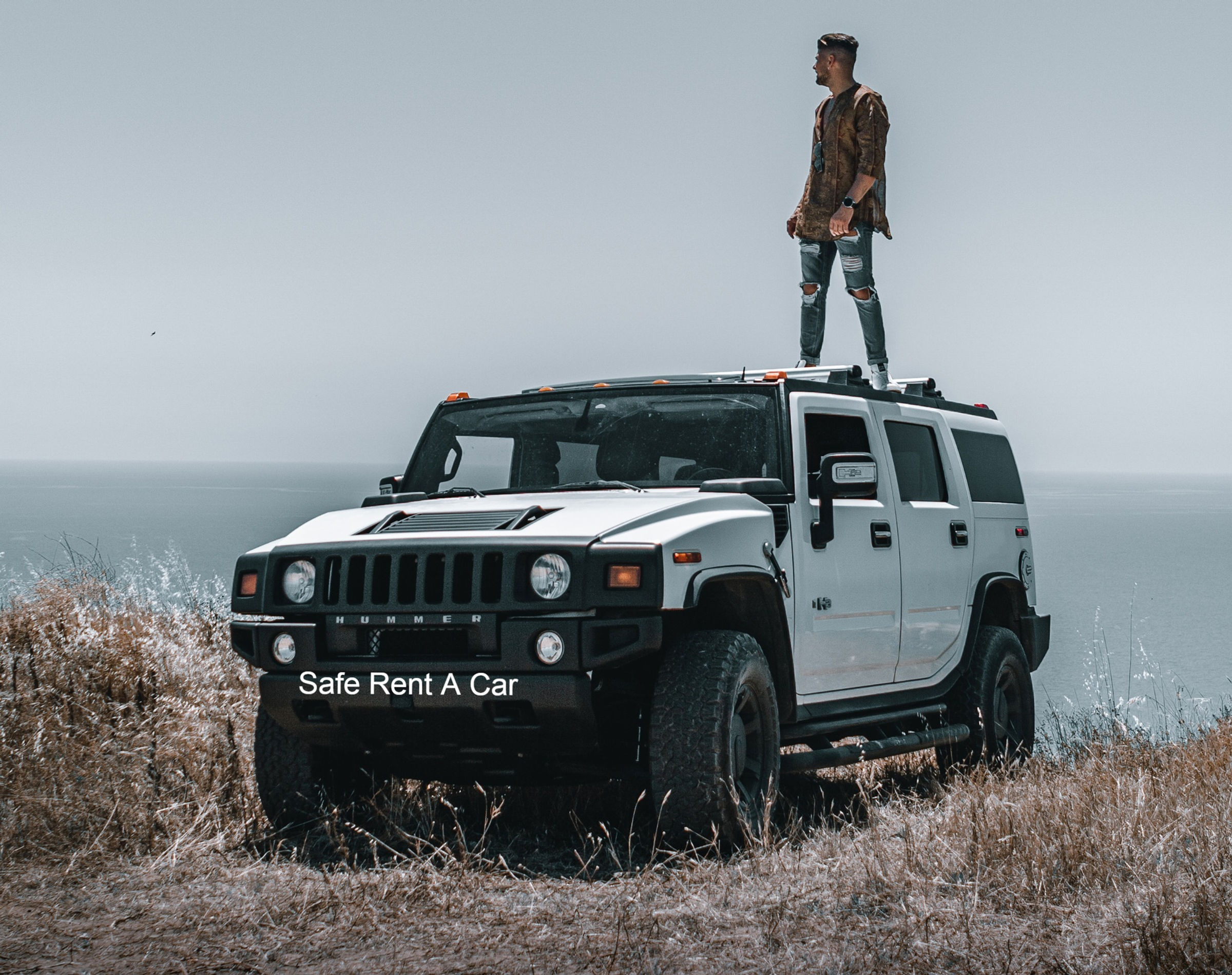 Man standing on a white Hummer H2, Safe Rent A Car