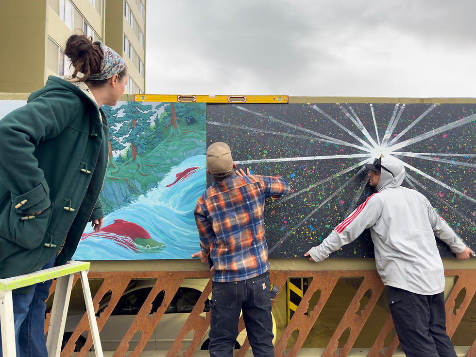 Dezarae Arrowsun watches the installation of mural panels on the Marine View Parking Garage on Tuesday, April 28, 2026. (Dan Hubert / Last Frontier Aerial)