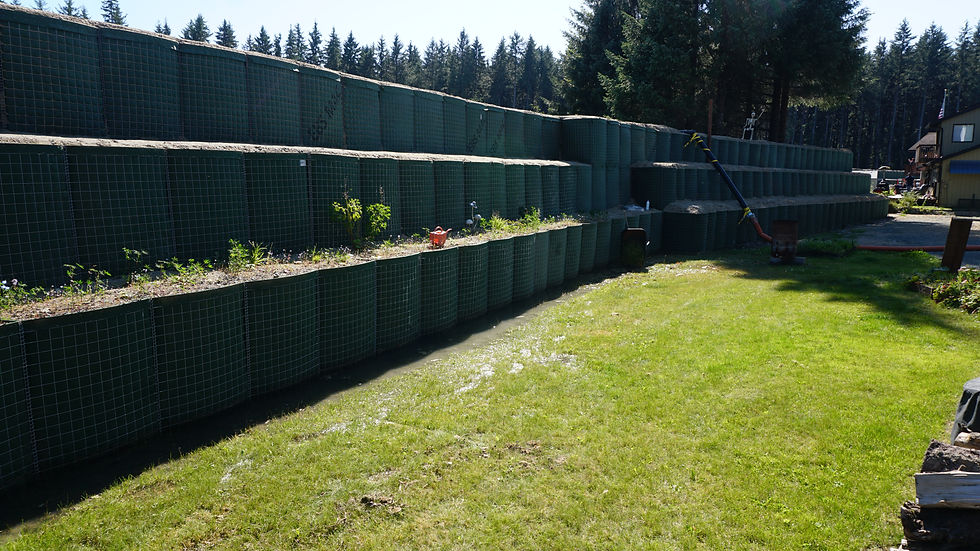 Water seeps from under the HESCO barriers in Melissa Browne's backyard and is pumped out on Meander Way on Thursday, Aug. 13, 2026. (Ellie Ruel / Juneau Independent)