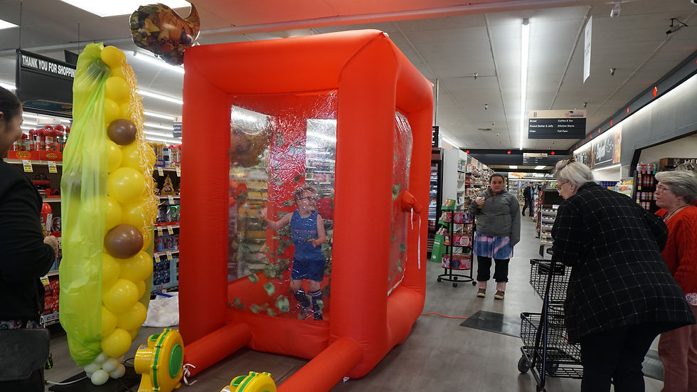 Young participants try their hand at the "cash cube" at the annual Caring is Sharing food drive at Super Bear IGA on Saturday, Nov. 22, 2025. (Ellie Ruel / Juneau Independent)