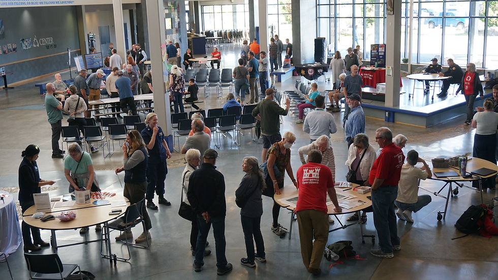 Attendees mingle and ask questions at a flood-preparedness open house in the Thunder Mountain Middle School commons on Tuesday, June 9, 2026. (Ellie Ruel / Juneau Independent)