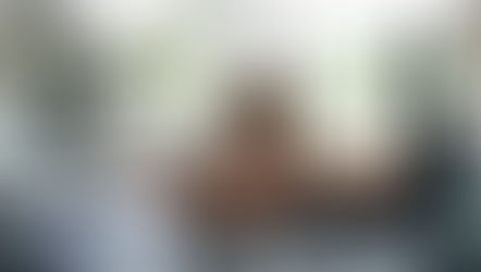 A women smiling from inside a golf cart.