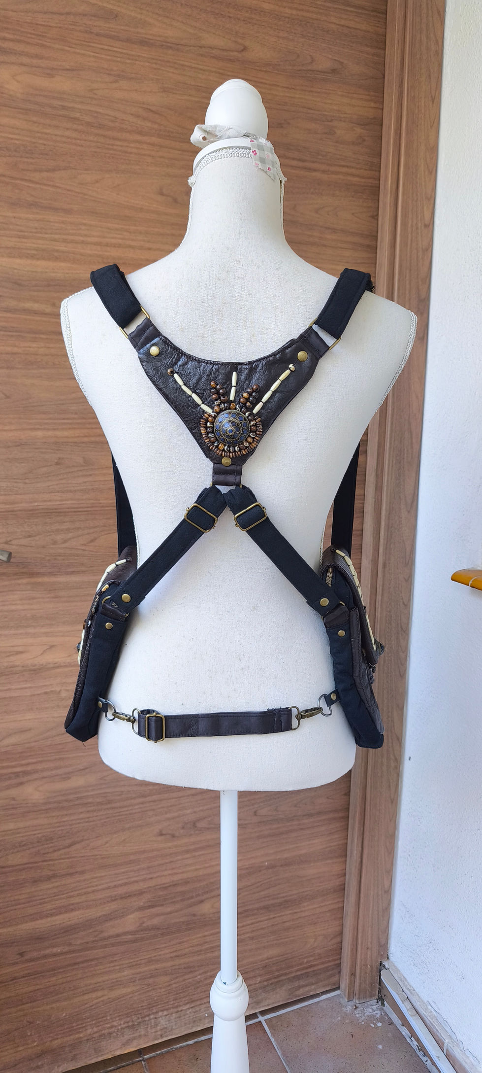 Accesorio de diseño único tipo pistolera con estética mística y detalles ornamentales hechos a mano.