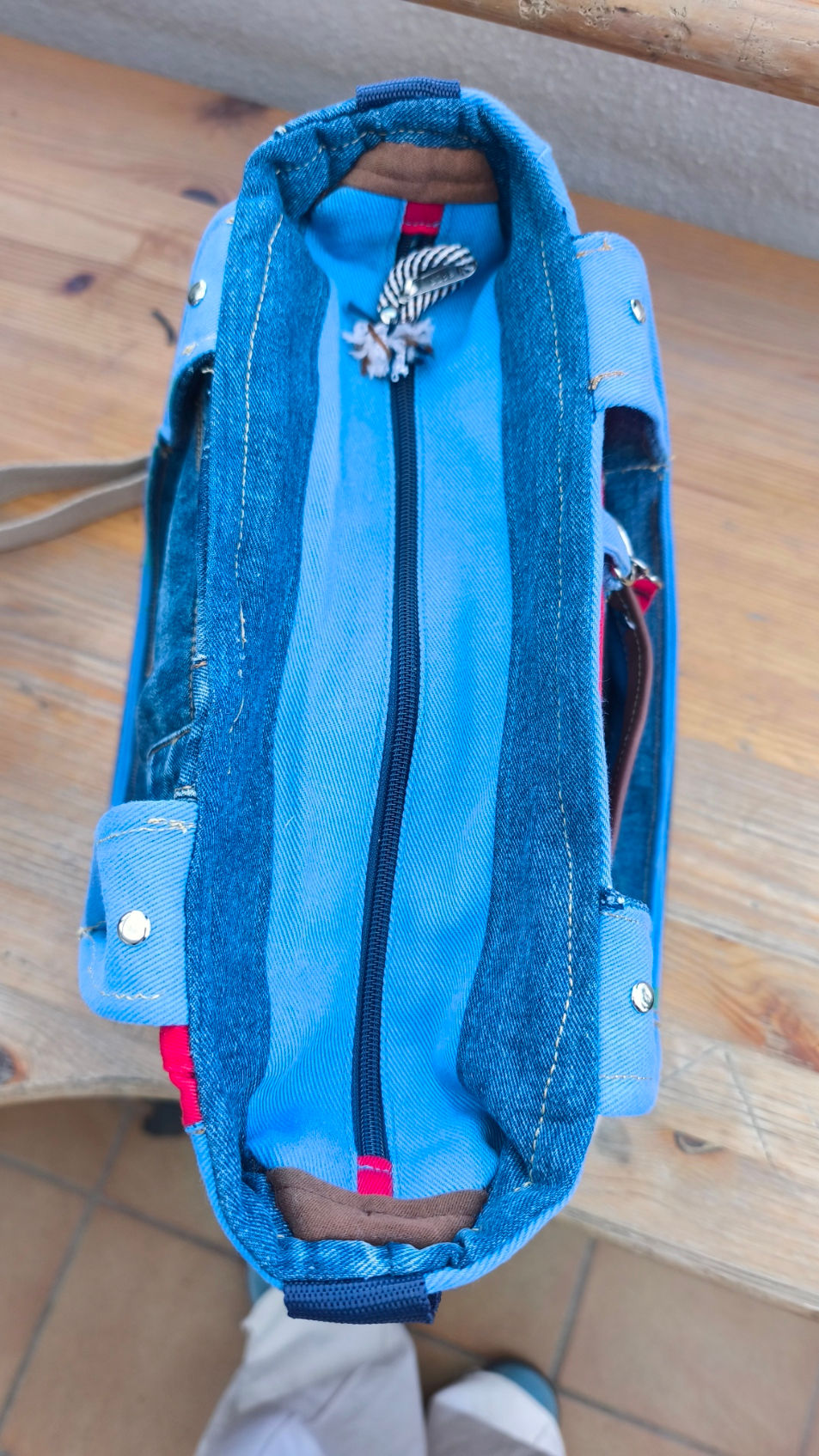 Handmade tote bag, recycled fabrics, denim in different blues and contrasting pieces in red, cowboy handles with silver studs, adjustable strap, brand patch in caramel synthetic leather, flowered interior with large pockets and carabiner for keys