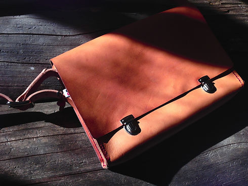 Dark Leather Messenger Bag On Wood