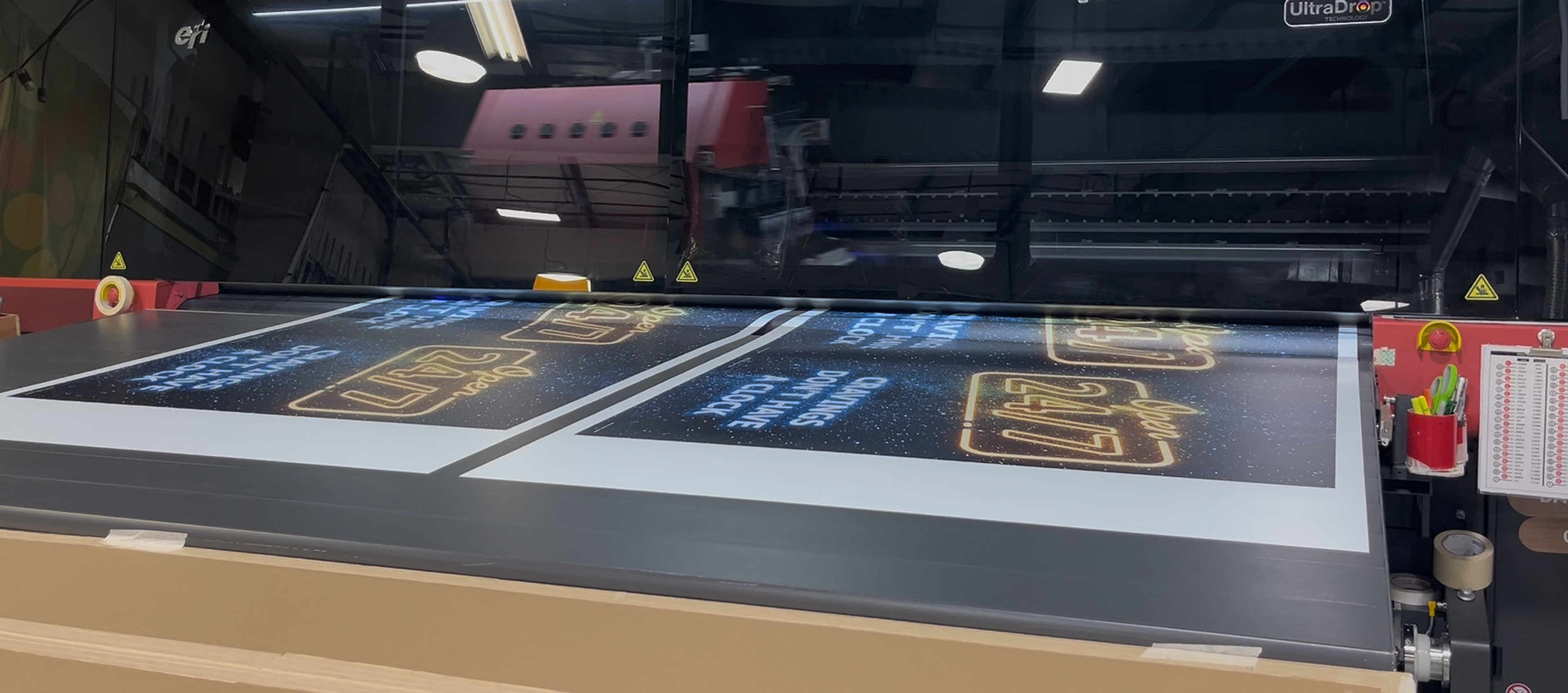 Large VUTEk h5 printer in a workshop printing glossy sign panels