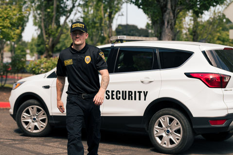Male security guard confidently walking away from his vehicle during a security brand photo and video shoot in Portland, Oregon