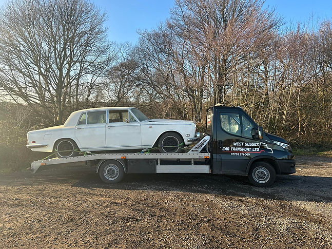 Classic white car on a tow truck
