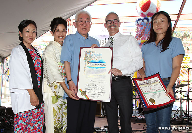 ロサンゼルス市から贈られた表彰状を披露する白松さん（左から３人目）。右端が撫養委員長