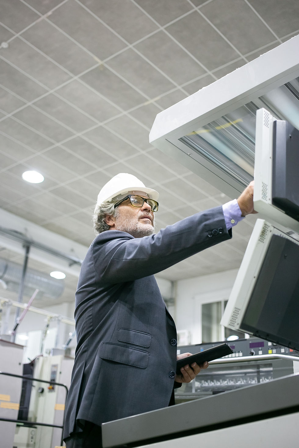serious-mature-male-plant-engineer-operating-industrial-machine-pushing-buttons-control-pa