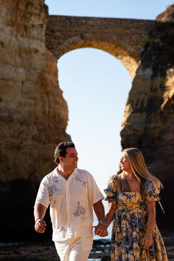 Couple holding hands along the Algarve shoreline