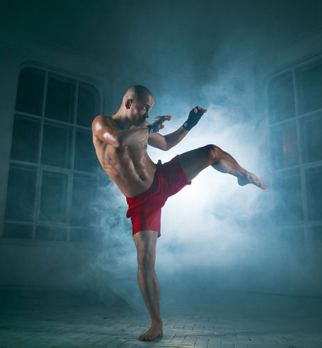 young-man-kickboxing-in-blue-smoke.jpg