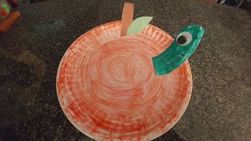 A paper plate apple with a worm in it