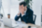 business owner in ottawa sitting at his desk with heads in hands