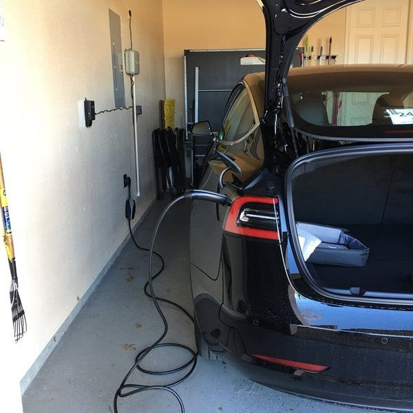 Tesla at a 240v outlet in a garage.