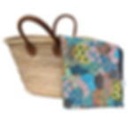 Multicolour floral waterproof picnic blanket folded beside woven picnic basket