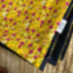 Close-up of yellow wild flowers waterproof picnic blanket with meadow-inspired design and navy waterproof lining.