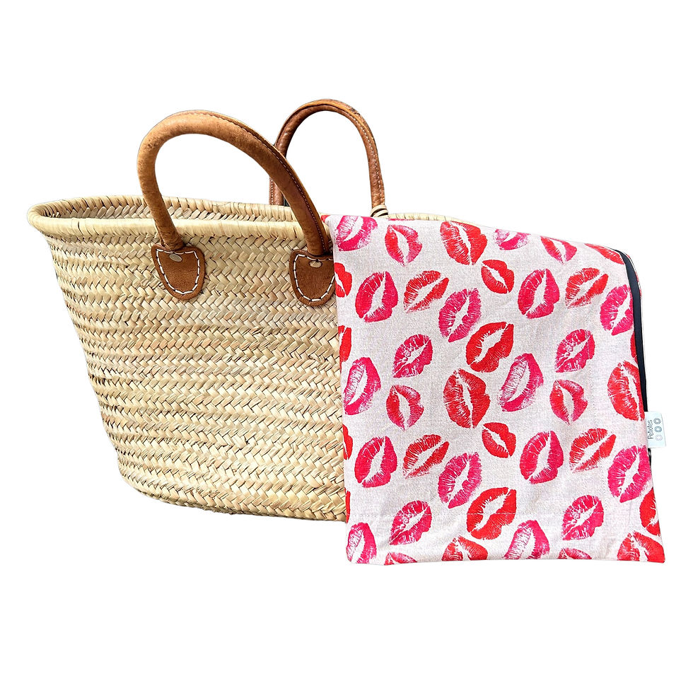 Red lips print waterproof picnic blanket folded beside woven picnic basket