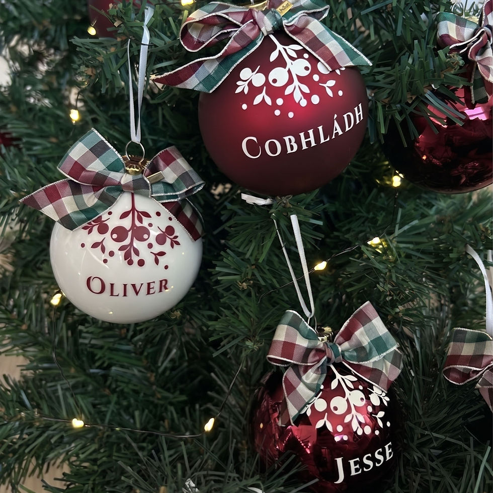 Personalised tartan baubles Oliver in cream glass and Cobhladh in burgundy on tree branch by Petiotes London