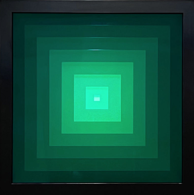 Square abstract light-object in which seven acrylic sheets are layered and chosen interactive light is green.