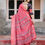 Thumbnail: Back view of a woman in a red silk saree featuring a beautiful bandhani print and a flowing pallu
