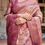 Thumbnail: Close-up of a premium dusty pink silk saree showcasing intricate traditional floral print and a rich woven zari border.