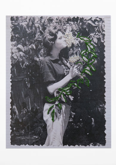Embroidered green leaves and white flowers on a black and white photograph