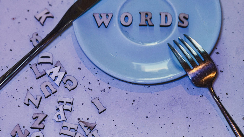 a blue plate with a word on it, with a knife and fork