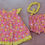 Thumbnail: Front view of dress. Pink background with yellow sunshine smiley faces. Trim is yellow gingham.