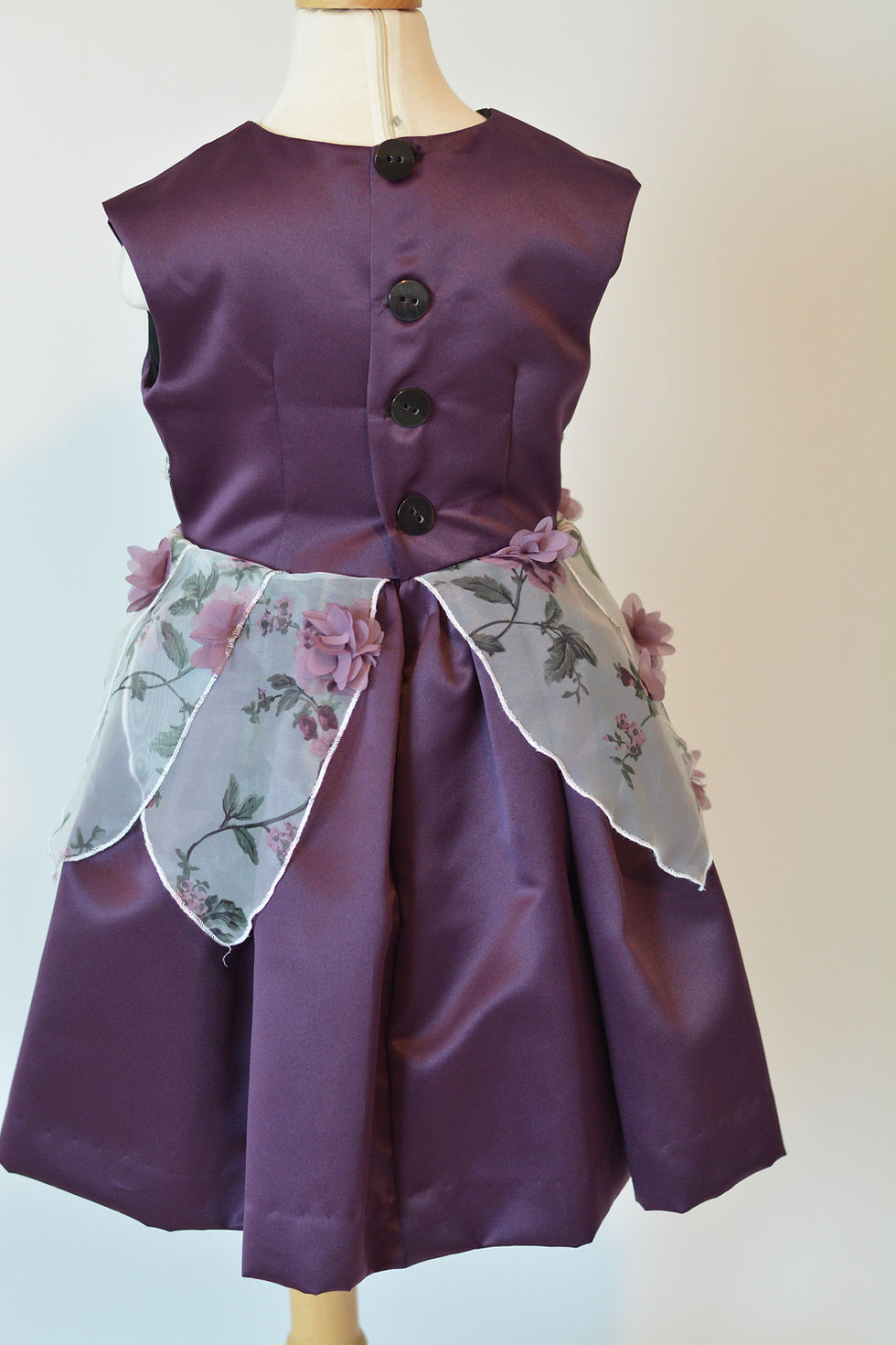 Thumbnail: A sleeveless eggplant dress adorned with a belt and translucent petal-like layers back view.