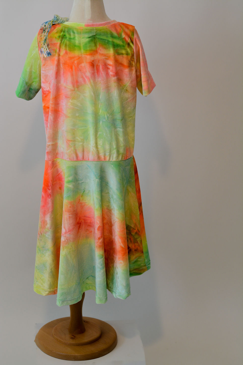 Thumbnail: Olivia Inspirations colorful tie-dye dress with shades of orange, yellow, and green. back view.