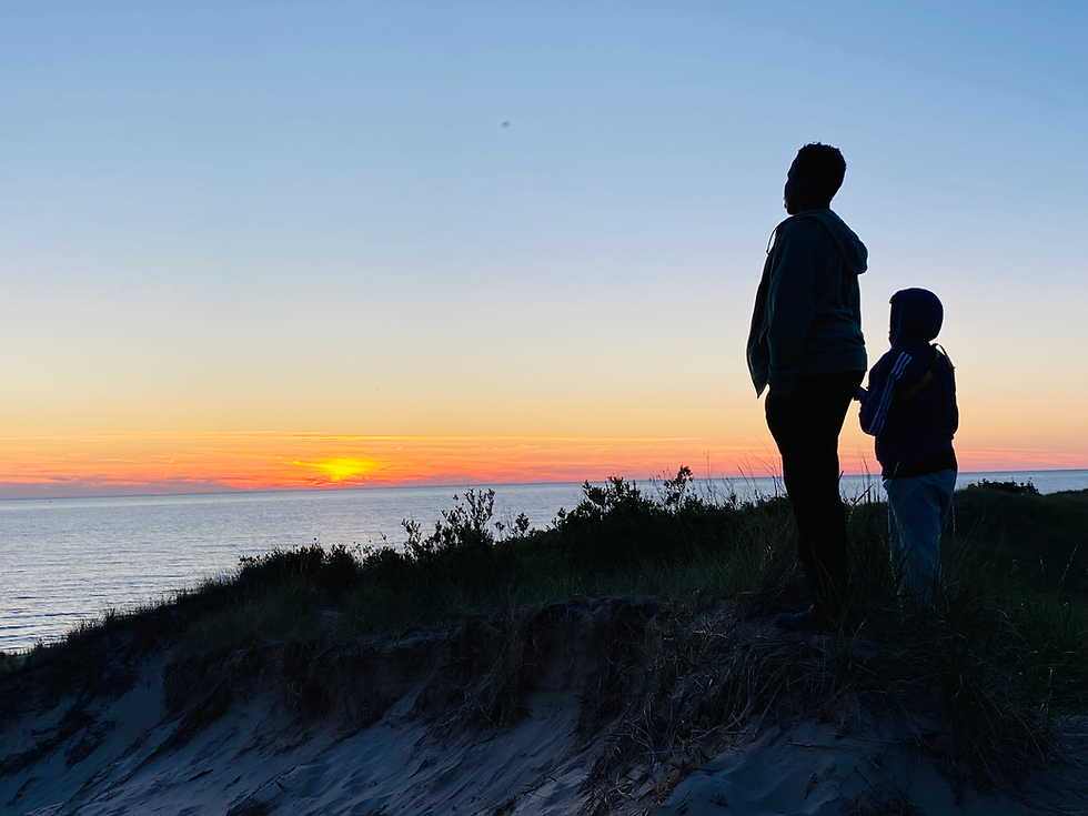 youth gazing at sunset over lake michigan
